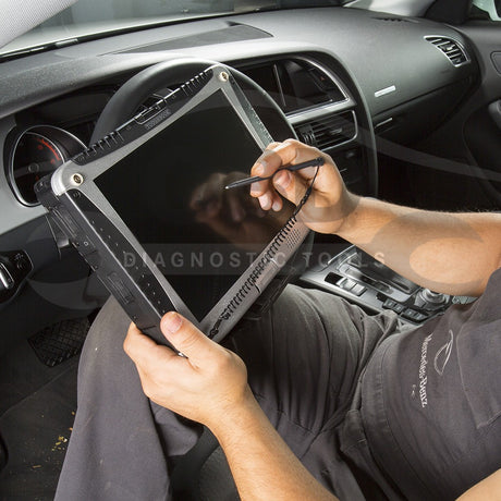 Mechaniker verwendet ein Profi Diagnose Gerät zur Auto Diagnostik im Fahrzeuginnenraum, zeigt ein Auto Diagnose Gerät im Einsatz.